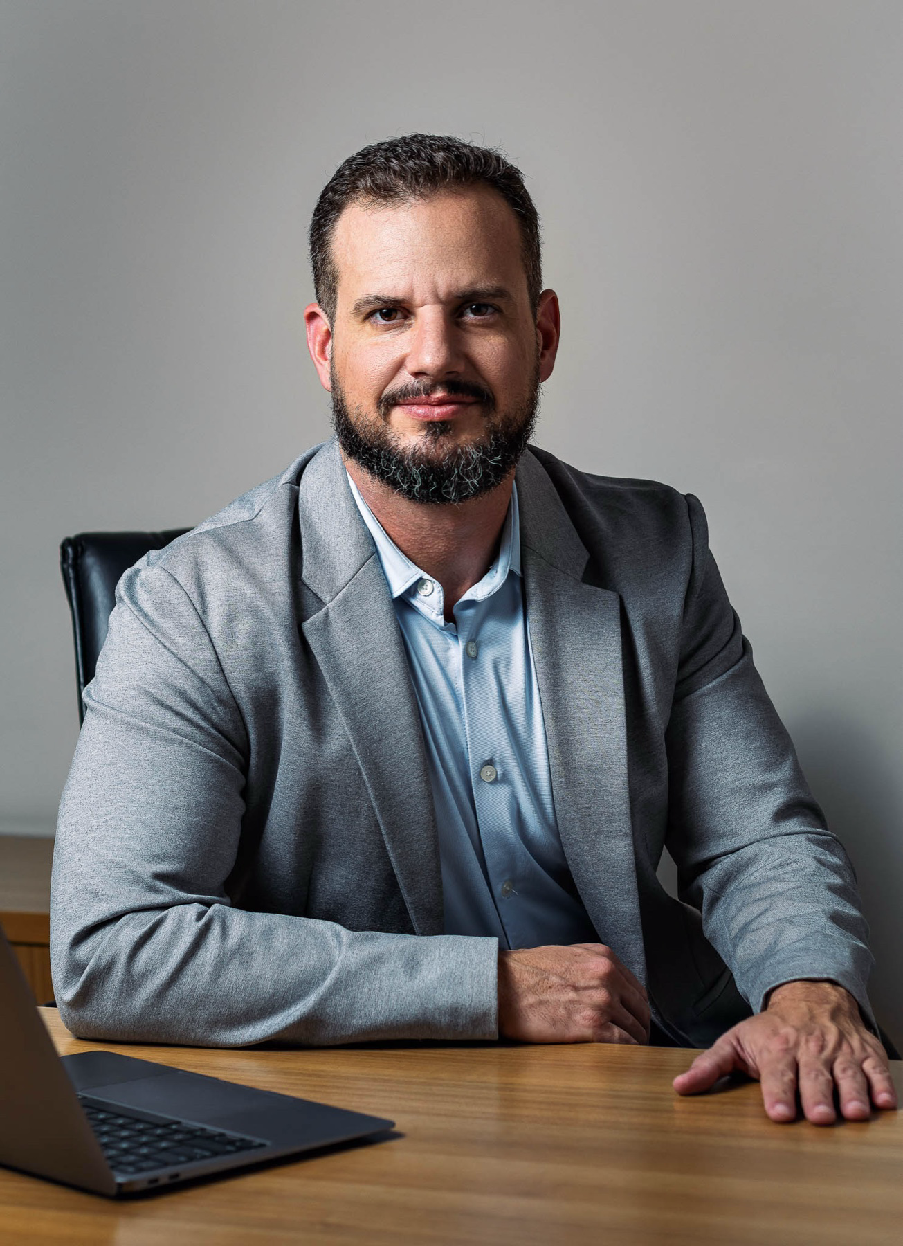 Retrato profissional de Eduardo Castan, de blazer cinza